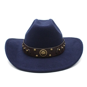 Detail of navy blue wool felt cowboy hat featuring brown leather band and gold studs