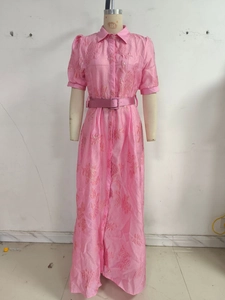 Detail of pink jacquard dress showing embossed floral texture and matching waist belt