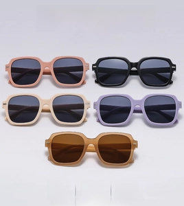Flat lay of square oversized sunglasses in five pastel colors with metal rivet detail