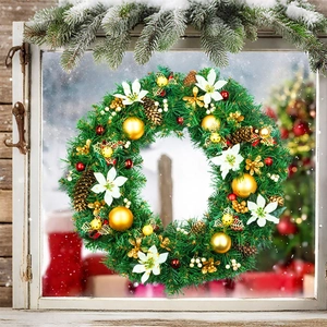 Detail of Christmas wreath with golden balls and white poinsettia on vintage white window