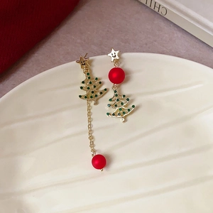 Detail of Christmas tree earrings with green rhinestones and red bead tassels on a tray