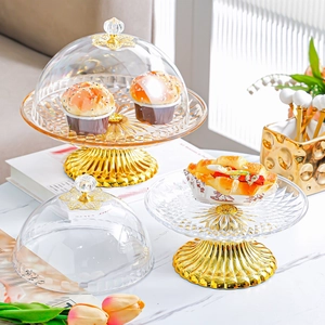 European style glass cake stand with golden metal base and clear lid for desserts
