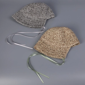 Detail of handmade woven straw hats with silk ties in grey and beige tones