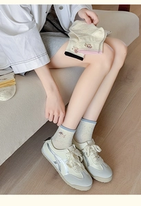 Close-up of cute cartoon dog embroidery on creamy white cotton knit ankle socks