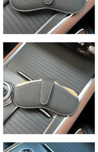 Black leather sunglasses pouch stored in car console featuring litchi grain texture