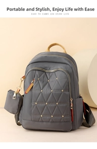Detalle de mochila de nailon gris con costuras acolchadas, tachuelas doradas y monedero