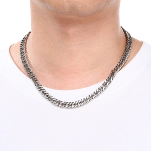 Close-up of a silver stainless steel flat curb chain necklace worn on a white t-shirt