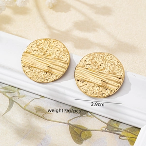 Close-up of golden irregular textured earrings featuring a 2.9cm diameter design