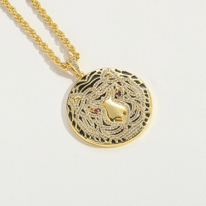 Detailed macro view of gold lion head pendant with crystal pavé and red stone eyes