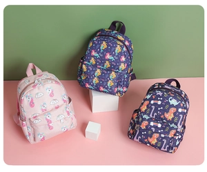 Tre zaini per bambini con stampe di unicorno, sirena e dinosauro su espositori colorati