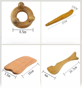 Detailed view of four polished sandalwood massage and guasha tools on white background