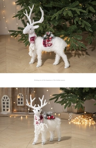 Close-up of a white plush reindeer with a red scarf and pinecones in a festive setting