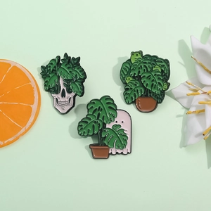 Three-piece punk enamel pin set featuring skull, ghost, and frog with monstera leaves