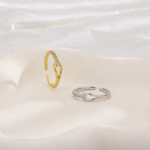 Detail of knotted zircon rings in gold and silver finish with minimalist pave stones
