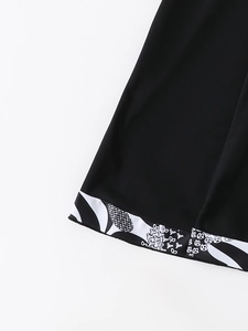 Detailed view of the printed hemline on a black tankini swimwear skirt with floral patterns