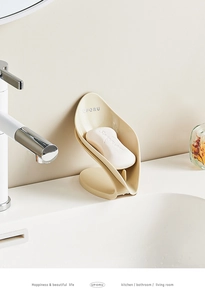 Detail of creative leaf-shaped self-draining soap holder in creamy beige for bathroom