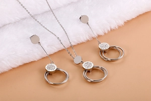 Detail of silver interlocking circles necklace and earrings set with crystal inlay