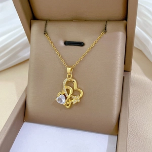 Vue détaillée du pendentif cœur doré avec détail papillon dans son écrin à bijoux