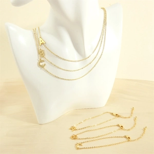 Detail showing 18K gold-plated initial pendants A, B, and C on necklace and bracelet set