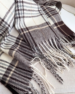 Close-up of soft plaid scarf texture in brown and beige with fringe tassel details