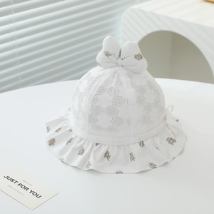 Vue détaillée d'un chapeau de soleil en dentelle blanche pour bébé avec nœud fleuri