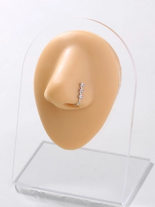 Detail showing a silver clip-on nose ring with three clear zircons on a silicone model