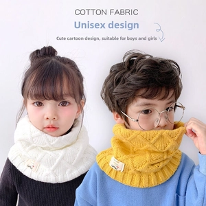 Detail of chunky knit cotton neck warmer with cable texture for kids in yellow and white