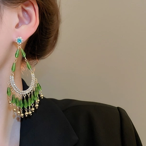 Gros plan sur un mannequin portant des boucles d'oreilles fleuries avec des perles vertes