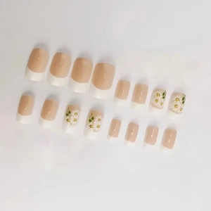 Short square press-on nails with French tip design and delicate white daisy floral patterns