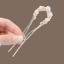 Detail of golden alloy hair clip with elegant pearls and sparkling rhinestones