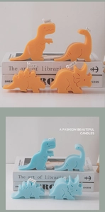 Detail of colorful dinosaur scented candles in orange and blue on decorative books