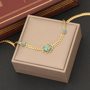 Close-up of golden turquoise flower necklace set displayed on a beige jewelry box