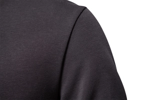 Detail shot of the reinforced shoulder stitching on a dark grey cotton knit sweatshirt