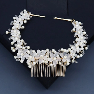 Close-up of golden bridal hair comb with white flowers, pearls and crystal beads