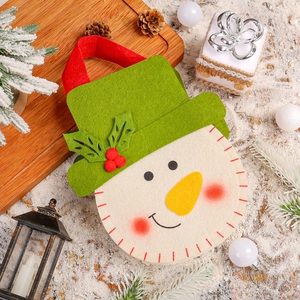 Christmas snowman felt gift bag with green hat and red handle on festive snowy background