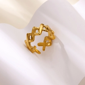 Close-up of golden 18k titanium steel ring with intricate hollow weave pattern on fabric