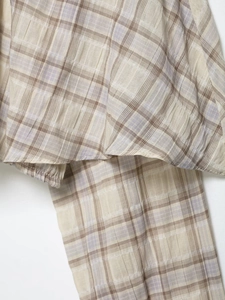 Detail of plaid fabric texture with beige and lavender checkered patterns on a cropped top