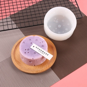 Detail of round bubble texture silicone mold and a purple handmade soap on wood tray