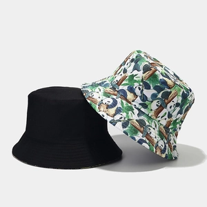 Detail of reversible bucket hat set showing classic black and cute panda bamboo print pattern