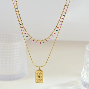 Detail of vintage gold layered necklace with colorful beads and celestial sun moon pendant