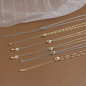 Close-up of gold and silver plated flat O-chains with lobster clasps and extension links