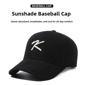Close-up of white letter K embroidery on black cotton twill baseball cap for sun protection