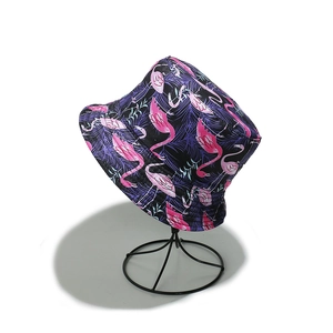Detail of summer sun hat featuring pink flamingo and green leaf prints on black fabric