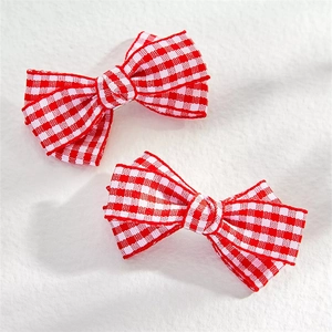 Detailed view of two red checkered fabric bow hair clips for stylish ponytail styling