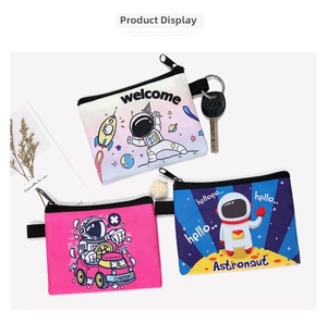Three astronaut canvas coin purses in pink, blue, and white with astronaut motifs
