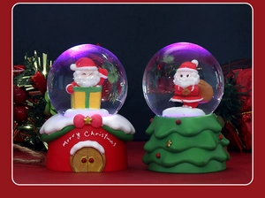 Detail of Christmas crystal ball with LED lights featuring Santa Claus on festive bases