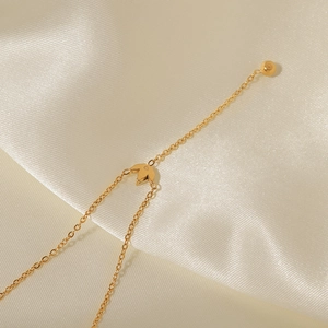Collier en titane doré 18 carats avec pendentif couronne en zircon sur fond de soie