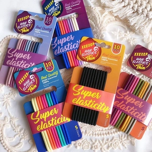 Close-up of high-elastic hair ties in various colors on white lace background