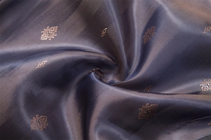 Macro shot of dark blue jacquard fabric with golden geometric patterns and silky sheen