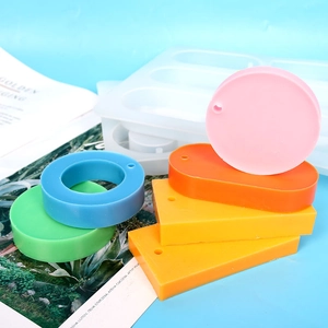 Various colorful resin shapes displayed next to a 6-cavity rectangular silicone mold